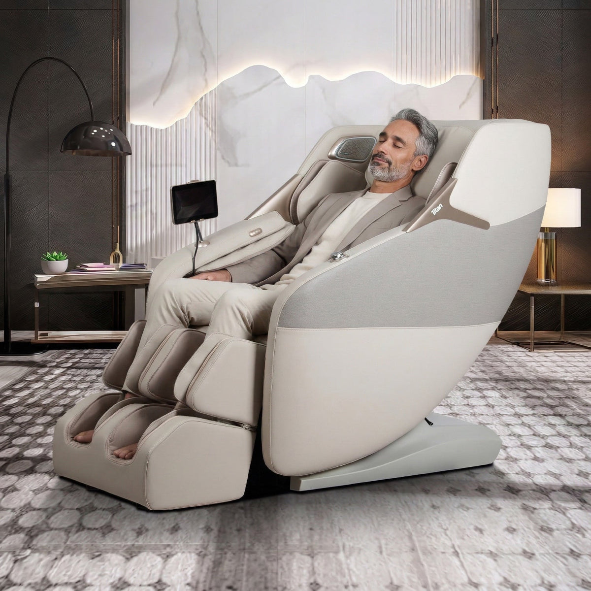 Man relaxing in a reclined Taupe Titan Pro 4D Astro massage chair in a modern living room