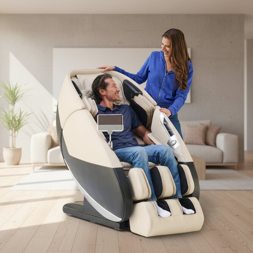 Woman standing beside a man using the Cream Human Touch Super Novo 3.0 massage chair